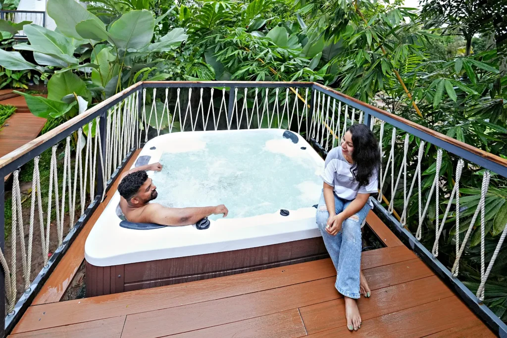 Couple relaxing in a private Jacuzzi at a glamping dome, Wayanad