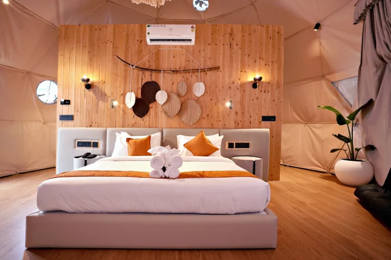King bed against a timber feature wall in a glamping dome