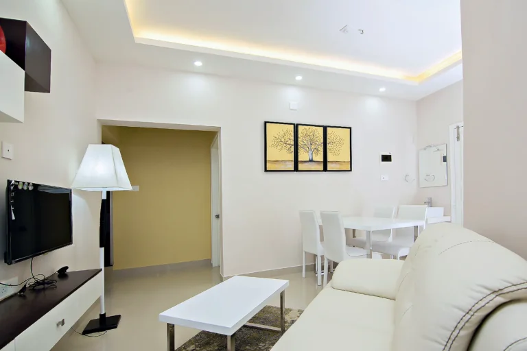 One-bedroom apartment living room with TV and dining table, Le Villagio Wayanad