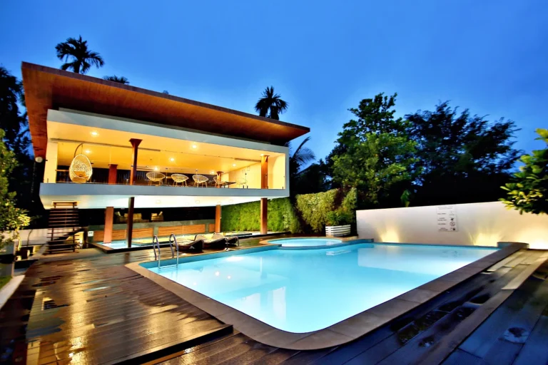 Swimming pool and rooftop restaurant lit up in the evening, Wayanad