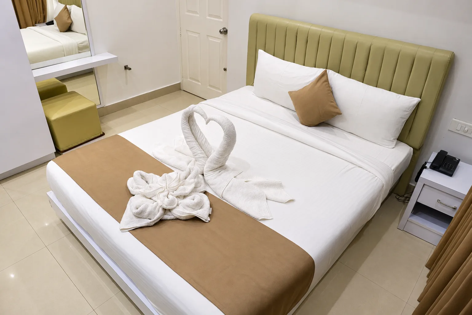 Air-conditioned apartment bedroom with king bed and swan towel art, Le Villagio Wayanad